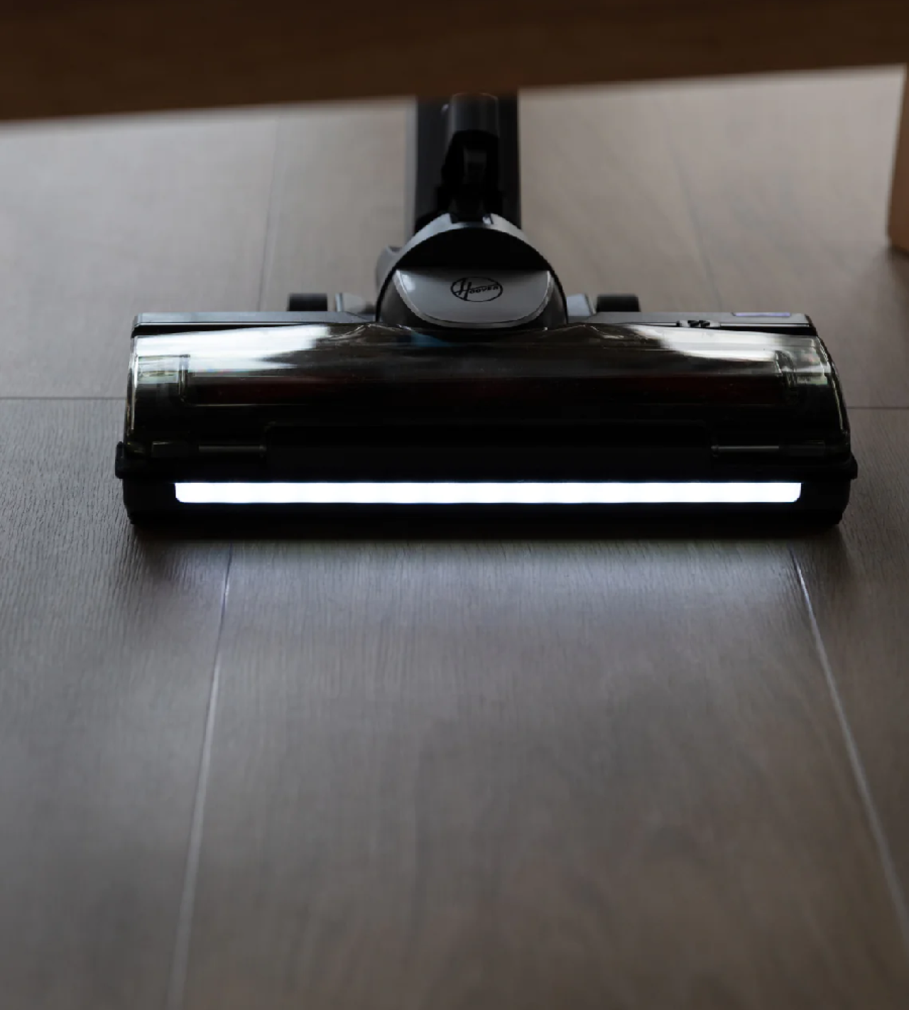 Hoover Anti Twist Home headlight in action under a stilted sofa